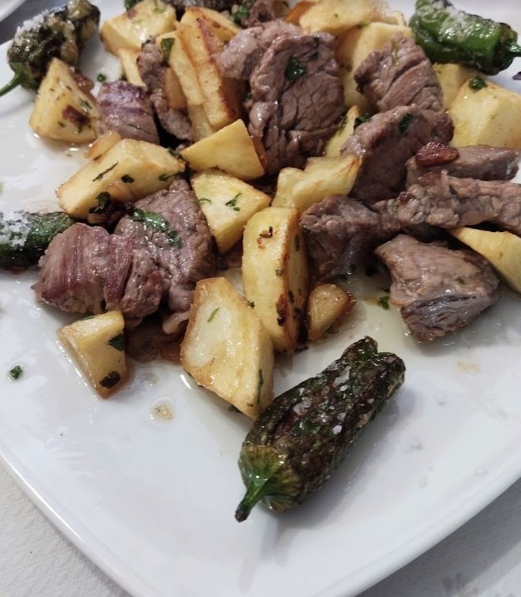 Carne troceada con papas salteadas y pimientos de padrón